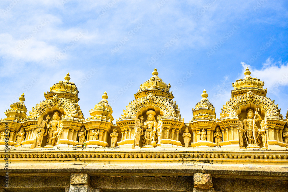 The portrait view of a structure on the top of a temple with blue sky background