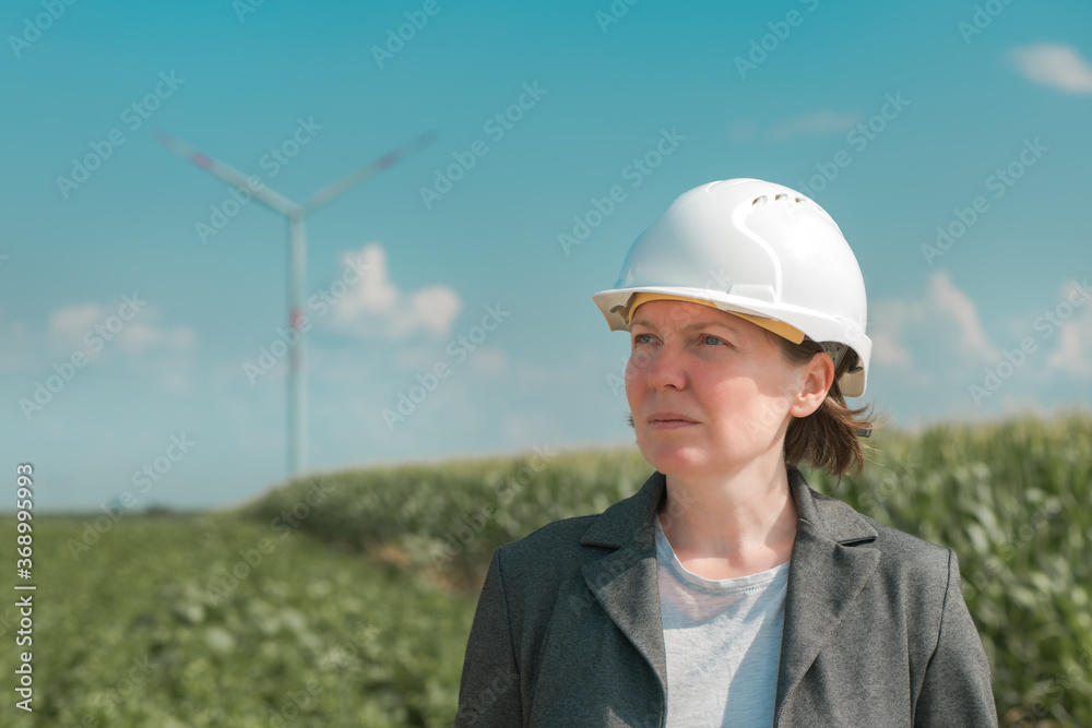 Portrait of female engineer on modern wind turbine farm Portrait of female engineer on modern wind turbine farm