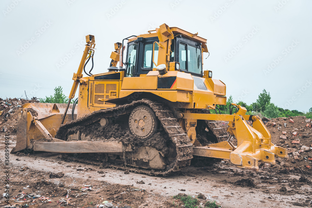 industrial machines clean the landfill and produce fine waste