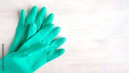 Flat lay composition with green gloves on a white wooden background