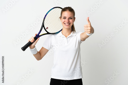 Young caucasian woman isolated on white background playing tennis and with thumb up © luismolinero