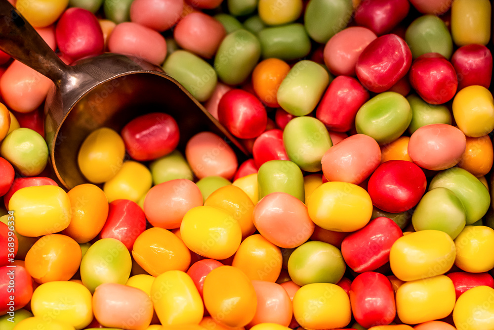 Fruit colorful gumballs candies background with the scoop. Pick and mix candy shop. Fruit colorful gumballs candies background with the scoop. Pick and mix candy shop.