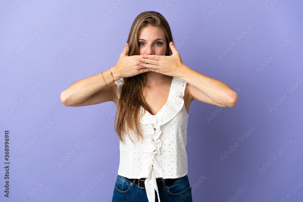 Young caucasian woman over isolated background covering mouth with hands Young caucasian woman over isolated background covering mouth with hands