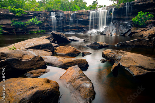 A small waterfall in the deep forest of the border of Thailand and Cambodia,Wang Yai  waterfall in tropical forest,Sisaket province,Thailand. Leaf moving low speed shutter blur. photo