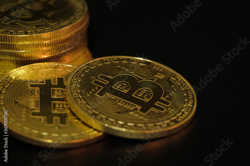 Physical Golden Bitcoin logo in the dark, New virtual money, bitcoin business exchange of trading screen on Closeup Bitcoins mockup of the money paper bank of various country, Economy