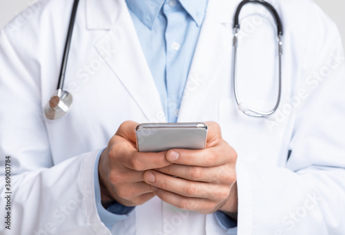 Close up of doctor holding smartphone in hands