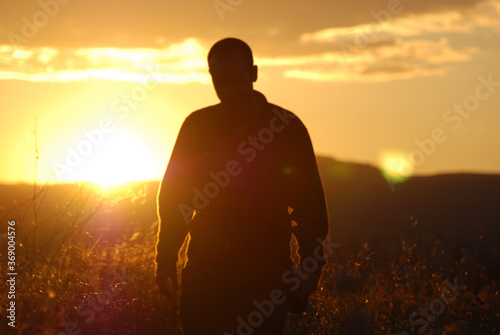 Man walking silhouette in a field at sunset  Catalonia  Spain