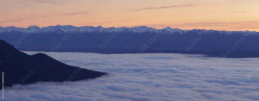 Sunrise with orange cloud cover seen from Luxmore Hut in the Fiordland National Park along the Kepler Track near Te Anau in New Zealand. Sunrise with orange cloud cover seen from Luxmore Hut in the Fiordland National Park along the Kepler Track near Te Anau in New Zealand.