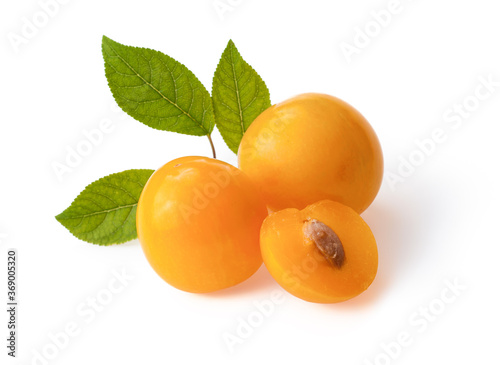 fresh yellow plum and a cut one on a white background