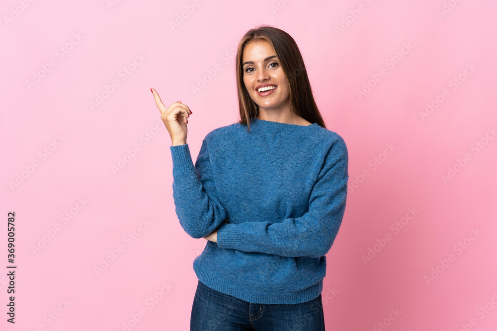 Young Uruguayan woman isolated on pink background happy and pointing up Young Uruguayan woman isolated on pink background happy and pointing up