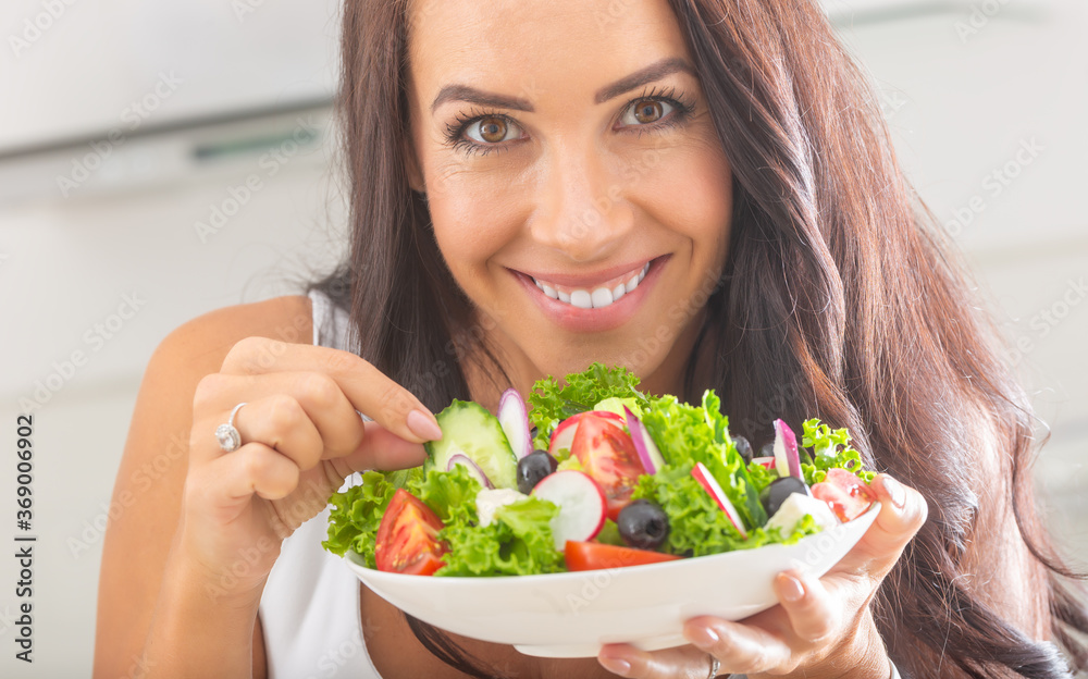 Attractive young and happy woman eating vegetable salad Attractive young and happy woman eating vegetable salad