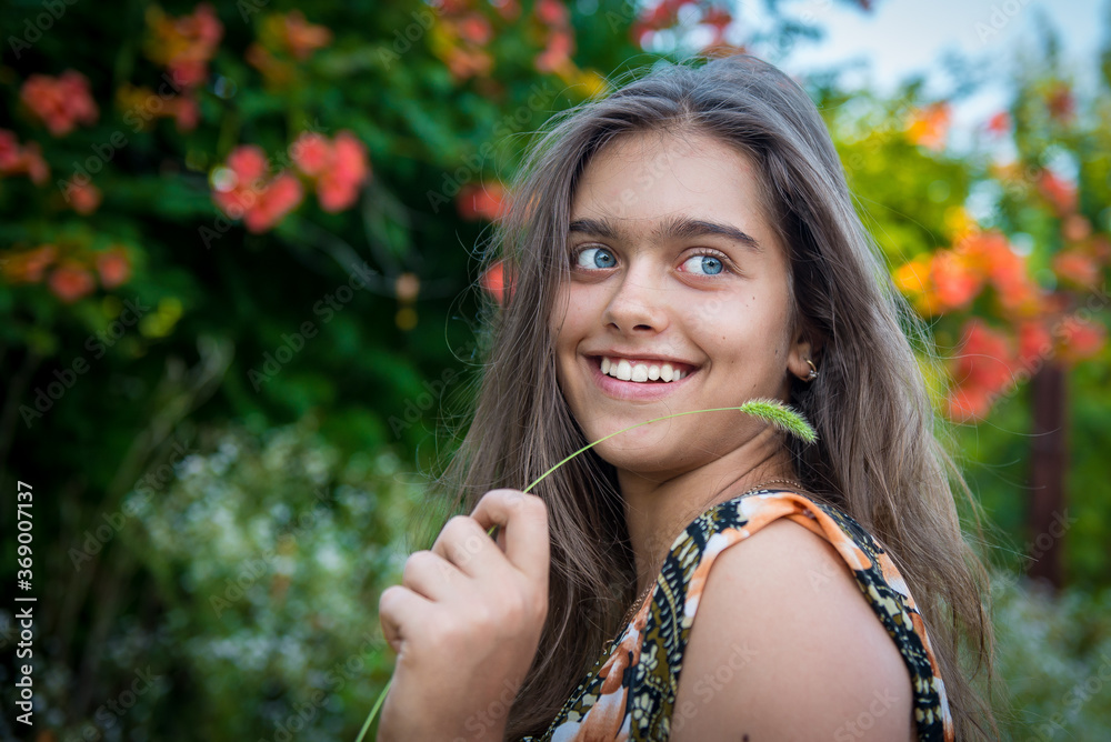 Girl with a spikelet near the face. Portrait of a beautiful smiling girl. Happy girl in summer. Summer girl closeup Girl with a spikelet near the face. Portrait of a beautiful smiling girl. Happy girl in summer. Summer girl closeup