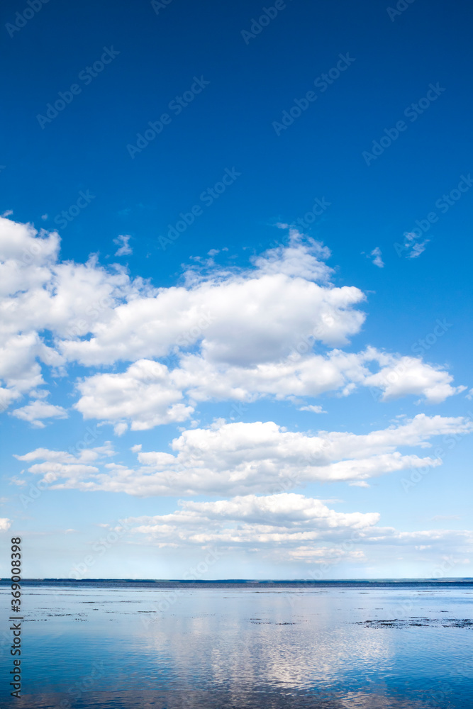 Fototapeta premium Beautiful blue cloudy sky and its reflection in water