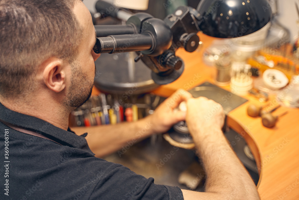 Fototapeta premium Craftsperson using a microscope in his work