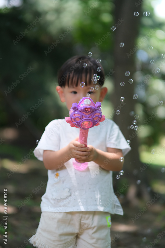 blurred one Asian toddler playing bubble toy at park blurred one Asian toddler playing bubble toy at park