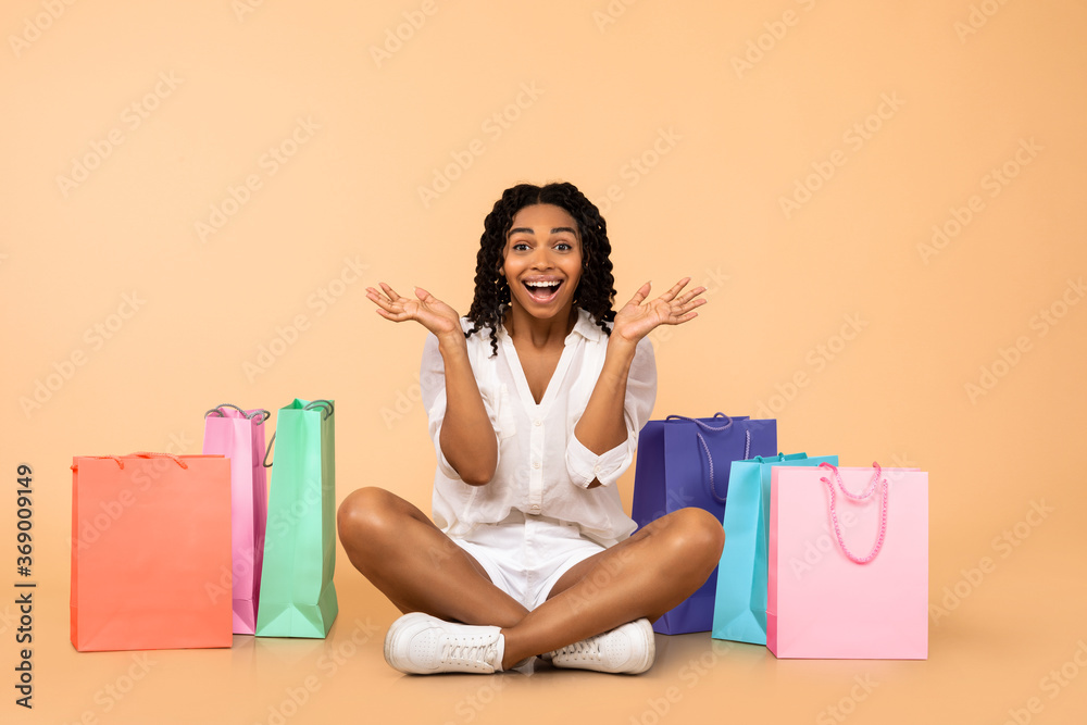 Black Girl Sitting Among Shopping Bags Shouting In Excitement, Studio Black Girl Sitting Among Shopping Bags Shouting In Excitement, Studio