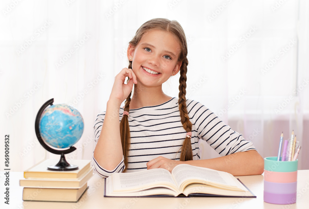 Education and school concept. Smiling happy child is sitting at the desk Education and school concept. Smiling happy child is sitting at the desk