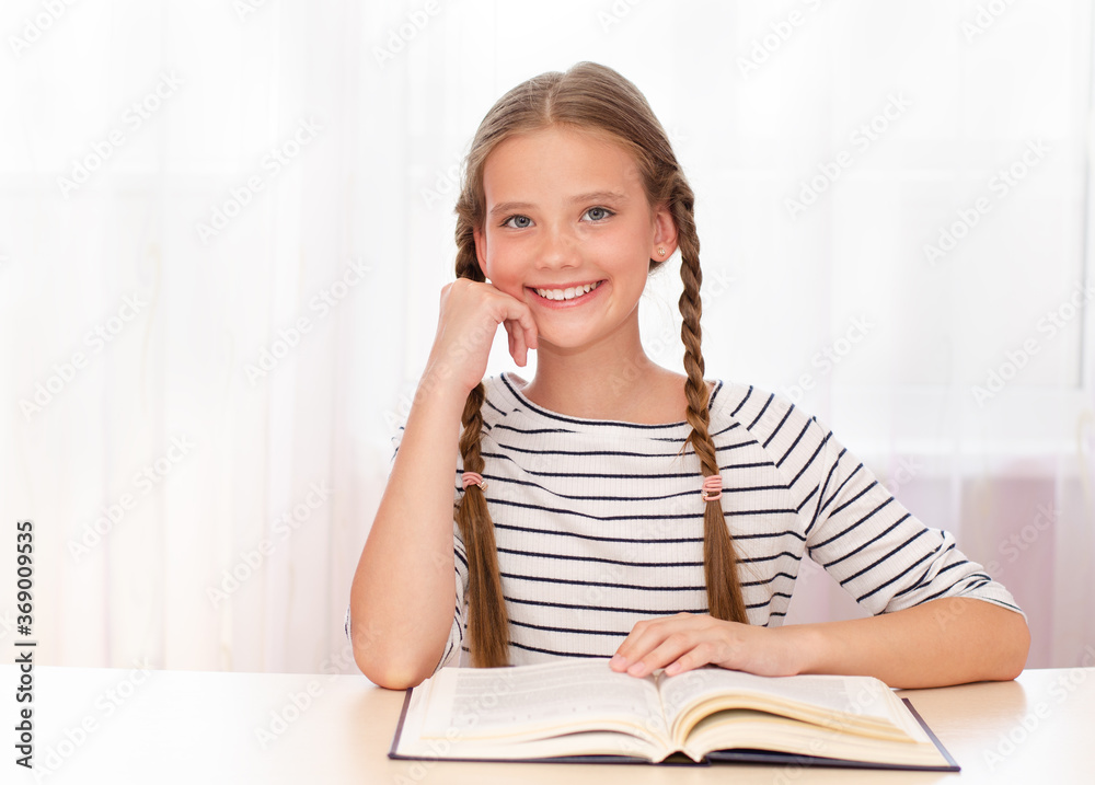 Education and school concept. Smiling happy child is sitting at the desk Education and school concept. Smiling happy child is sitting at the desk