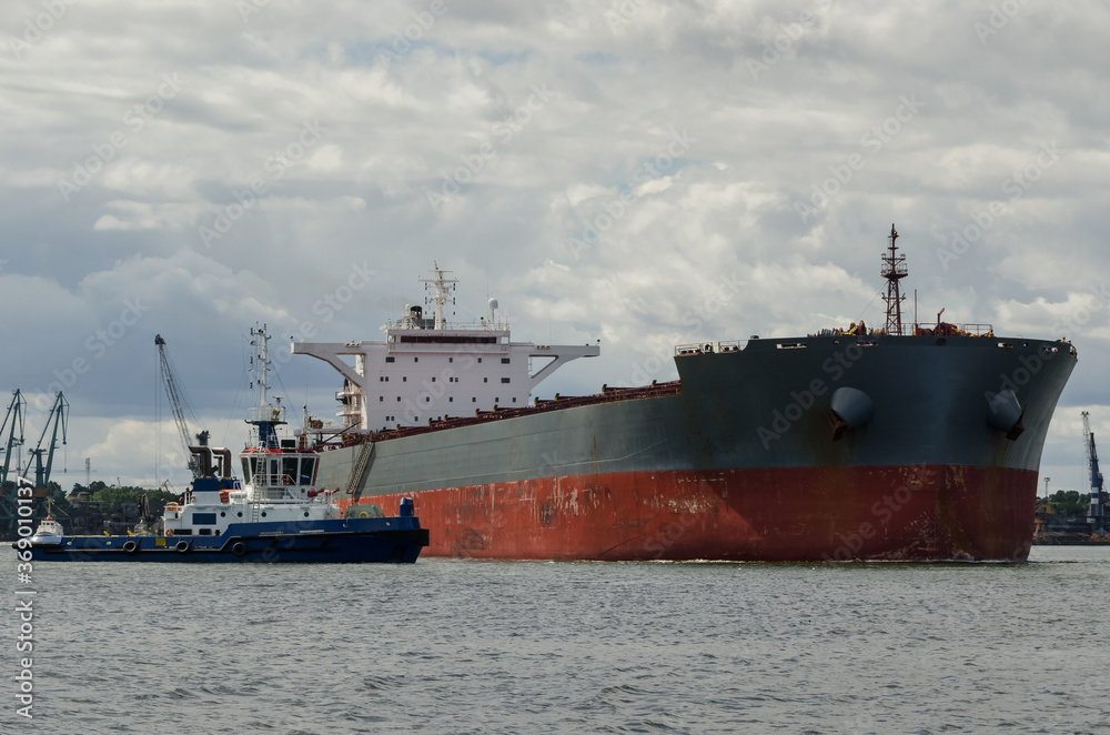 BULK CARRIER - A merchant vessel sails from port on a cruise to the sea
