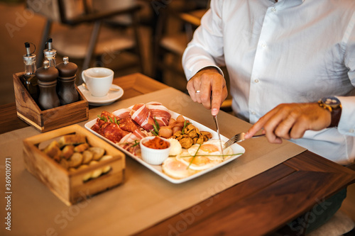 Close-up image of a businessman eating breakfast in the restaurant.