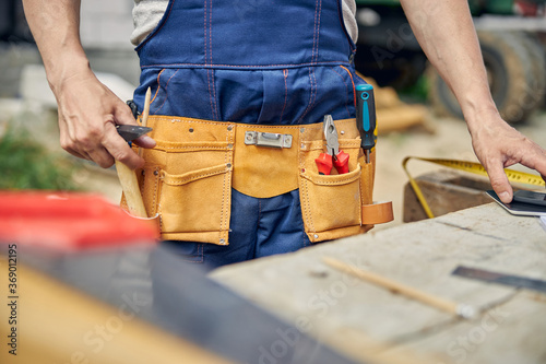 Caucasian male worker in overalls standing outside