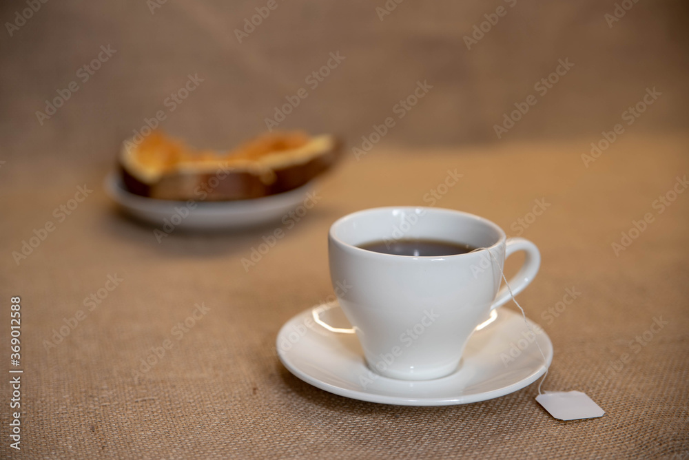 Fototapeta premium a white Cup of tea and a plate of sandwiches on the table