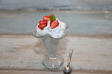 strawberries with cream and mint in a glass bowl