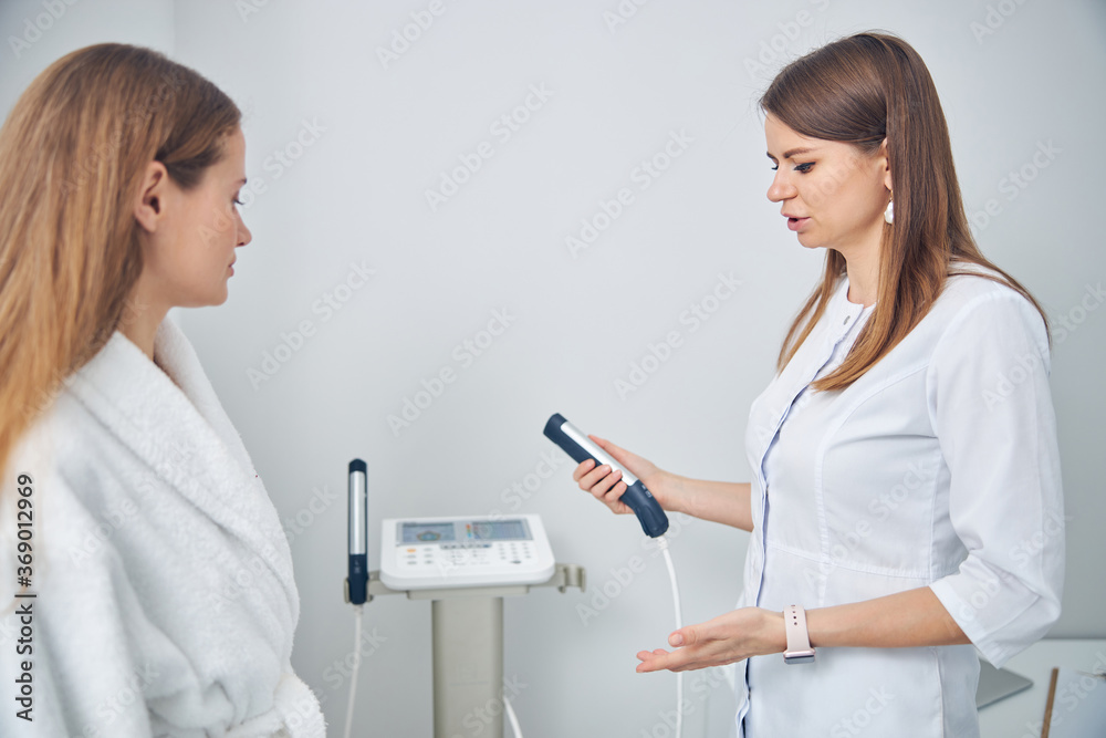 Two beautiful women talking about care using medicine machine Two beautiful women talking about care using medicine machine