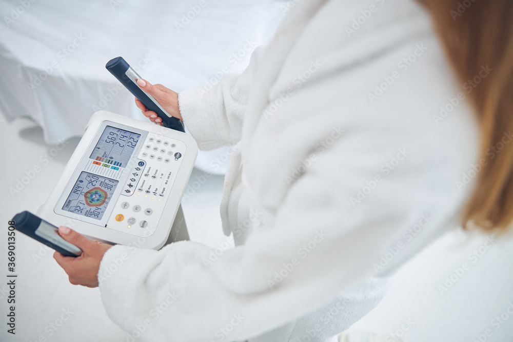 Woman is checking health indicators with body composition analyzed machine Woman is checking health indicators with body composition analyzed machine