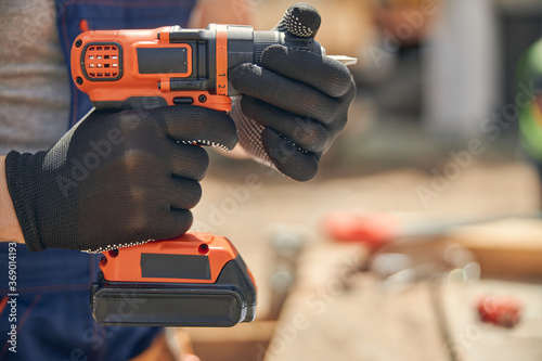 Male hands holding a cordless screw gun