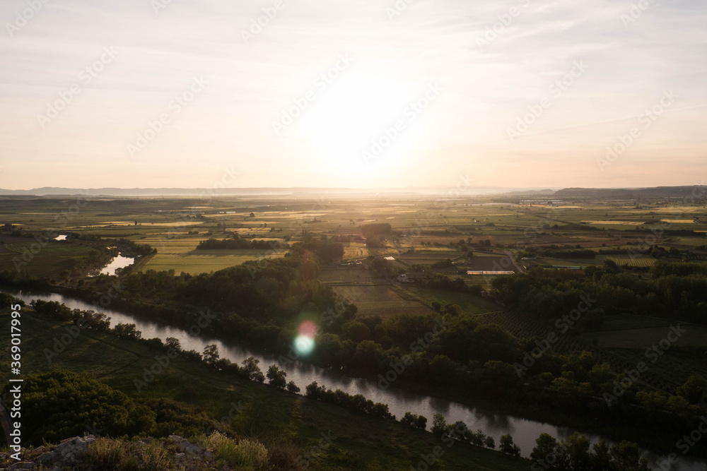 Paisaje al amanecer en un pueblo de Navarra, España, en el que se pueden observar diferentes campos y el río. 