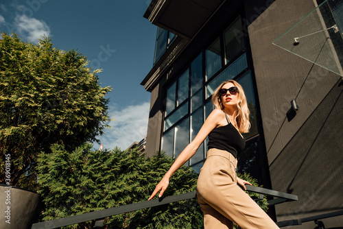 Portrait of beautiful young girl outdoors on hot, sunny, summer day, happy woman in sun glasses