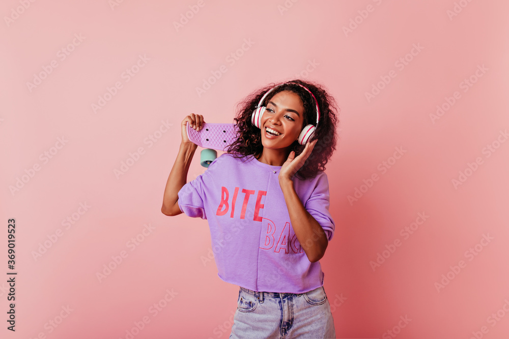 Elegant black girl in good mood enjoying music and dancing. Gorgeous curly african lady having fun in studio. Elegant black girl in good mood enjoying music and dancing. Gorgeous curly african lady having fun in studio.