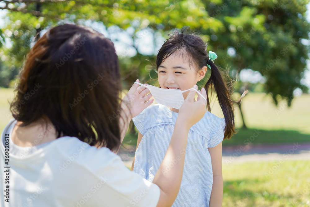 Naklejka premium 子どもにマスクを付けさせるお母さん