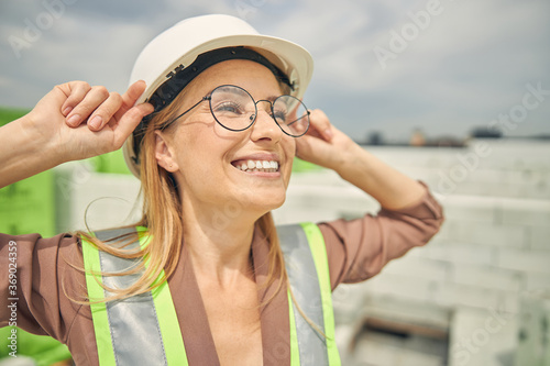 Attractive young blonde construction worker looking up