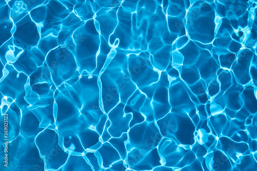 Blue swimming pool water background, sunny reflections