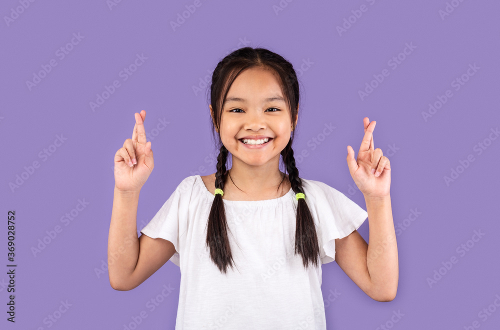 Asian Kid Girl Keeping Fingers Crossed Posing Over Purple Background Asian Kid Girl Keeping Fingers Crossed Posing Over Purple Background