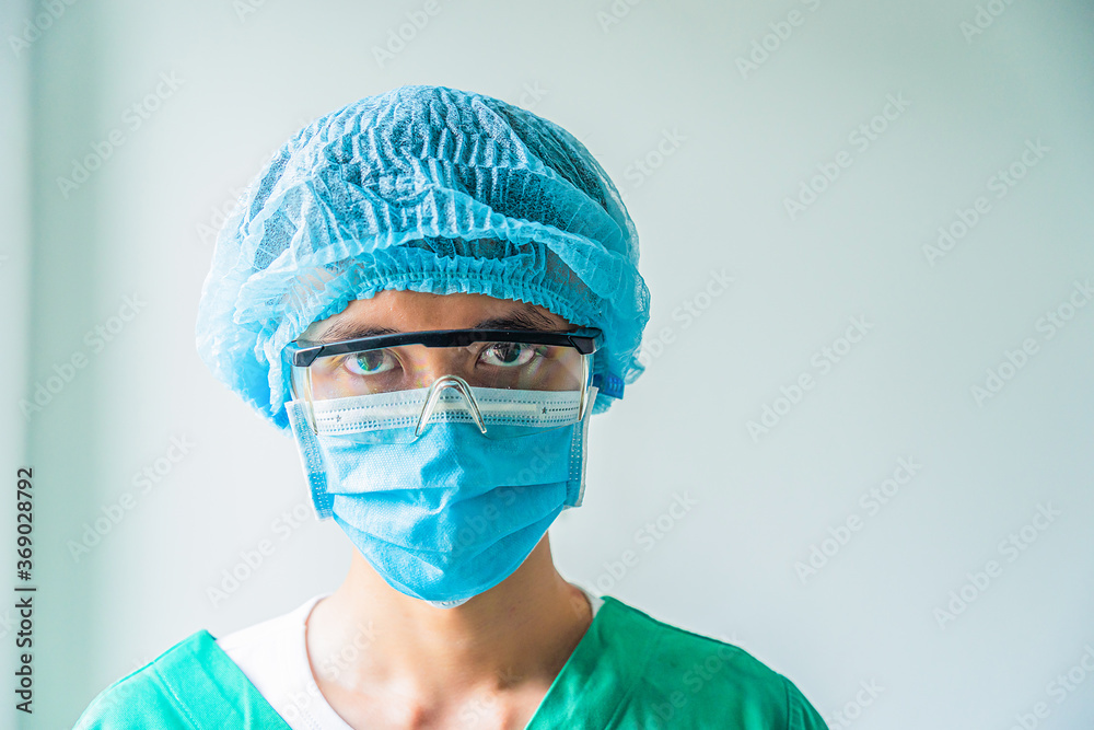 Closeup portrait of a mature male surgeon in the operating room, Male medical worker with medical mask looking seriously to camera, space for text, selective focus. Closeup portrait of a mature male surgeon in the operating room, Male medical worker with medical mask looking seriously to camera, space for text, selective focus.