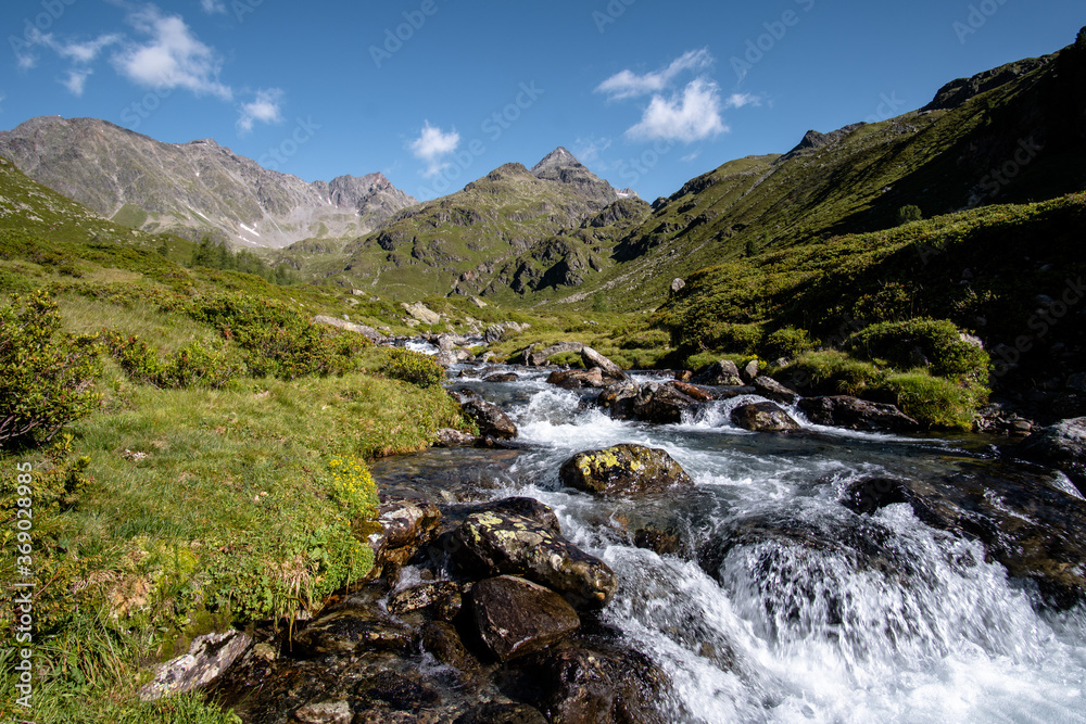 Bergbach (Debantbach bei Lienz) in Österreich mit Steinen und grünen Wiesen, im Hintergrund hohe Berge (Glödis, Debantgrad, Hochschober, Nationalpark hohe Tauern) Bergbach (Debantbach bei Lienz) in Österreich mit Steinen und grünen Wiesen, im Hintergrund hohe Berge (Glödis, Debantgrad, Hochschober, Nationalpark hohe Tauern)