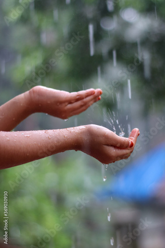 Kids hand in drizzling rain water. Kids playing in rain water