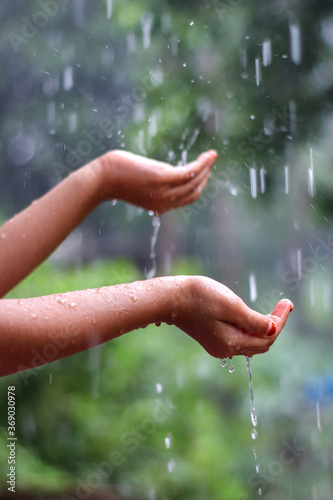 Kids hand in drizzling rain water. Kids playing in rain water
