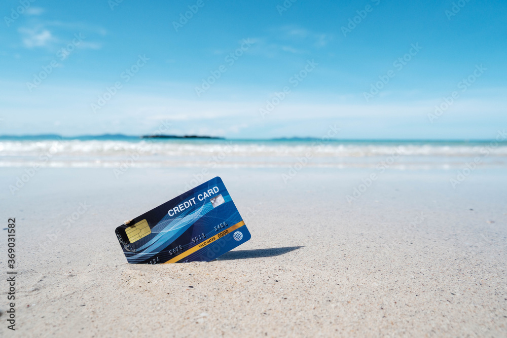 A blue credit card placed on a tropical beach - obrazy, fototapety, plakaty 