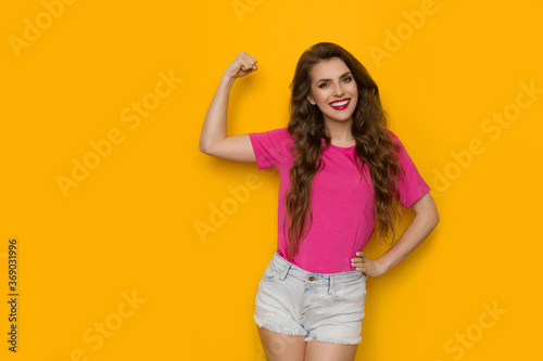 Confident Smiling Young Woman Is Standing With Fist Raised