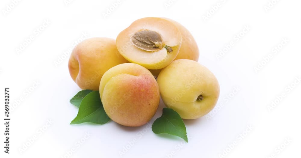 Ripe apricots with half and apricot leaves isolated on a white background, slowly full rotate clockwise 360 degrees. Ripe apricots with half and apricot leaves isolated on a white background, slowly full rotate clockwise 360 degrees.