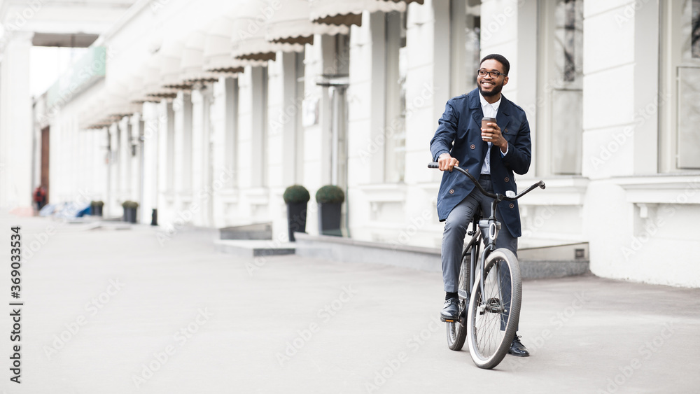 Handsome afro businessman riding his bike drinking tea