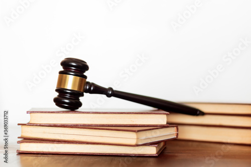 Judge's gavel and law books on wooden table. White background with copy space