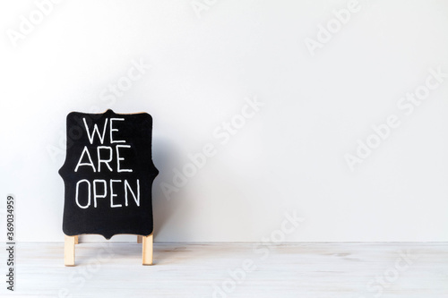 Blackboard with words WE ARE OPEN on white background