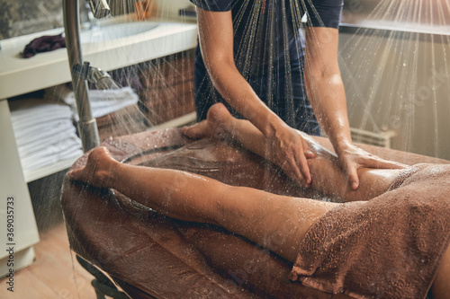 Papier peint Horizontal view of masseur massaging female calf