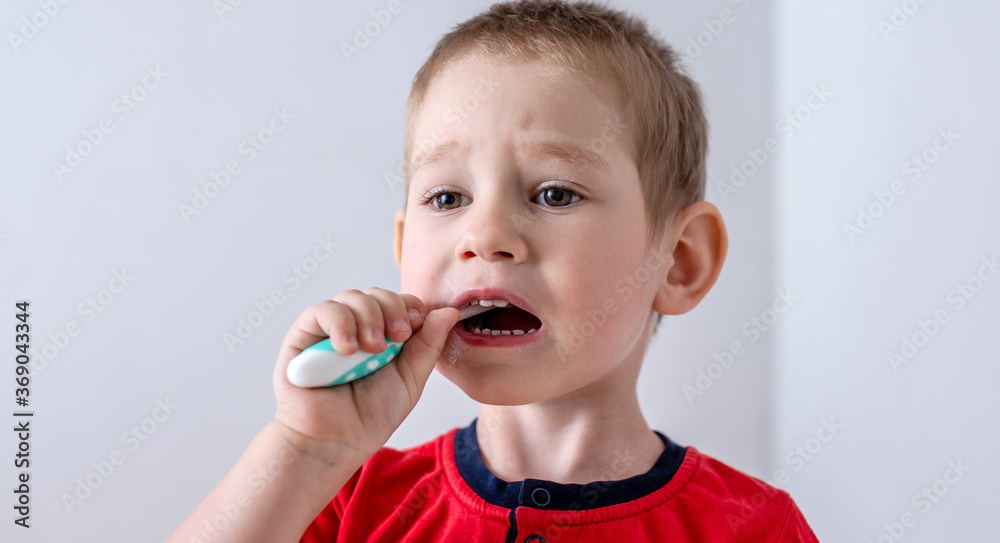 A little boy is learning to brush his teeth using a toothbrush. Concept of child hygiene and independence A little boy is learning to brush his teeth using a toothbrush. Concept of child hygiene and independence