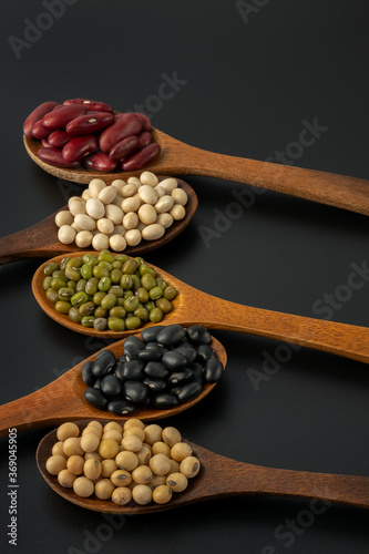 Collection of whole grains seeds isolated on black background. Healthy diet raw ingredients.